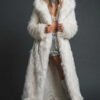 Woman wearing a long white faux fur hooded coat at a night festival, back view showing plush texture.