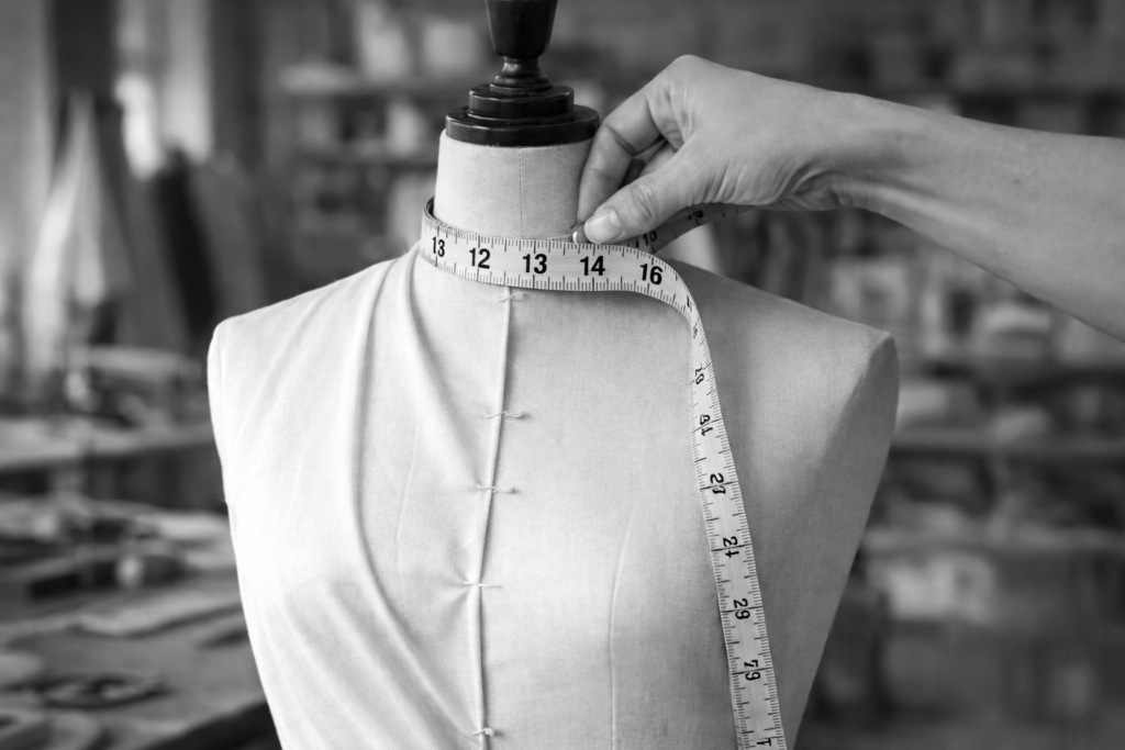 Close-up of measuring tape on mannequin neck demonstrating precise fit for ZEVQ custom high collar capes and festival wear.