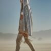 ZEVQ's oversized silver sequin hooded jacket worn at a festival, creating a liquid-metal sparkle effect.