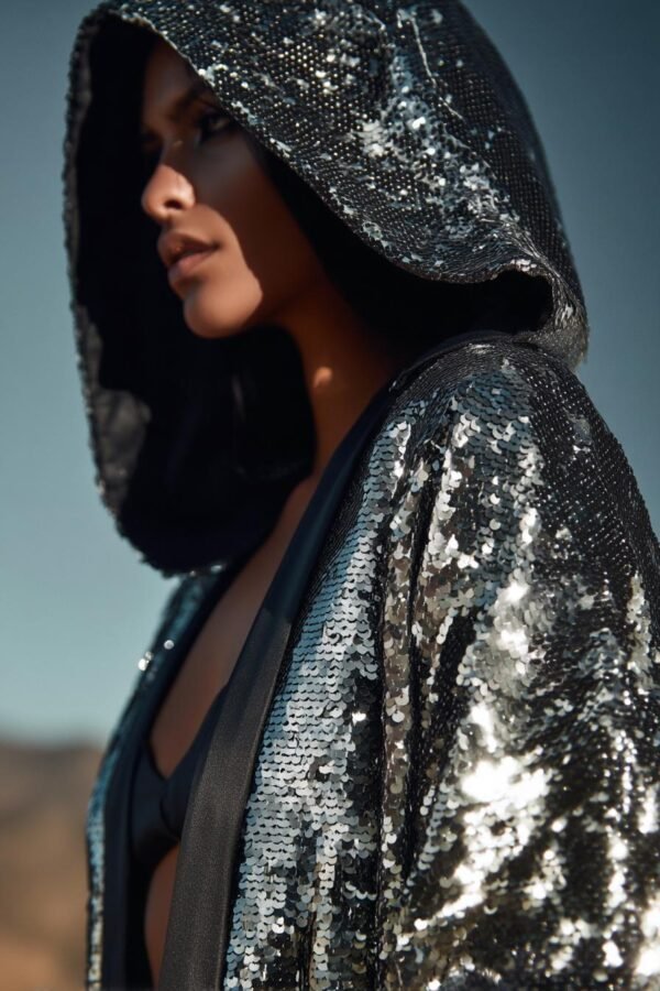 ZEVQ Silver Sequin Hooded Duster custom print maxi coat creating a liquid metal effect at a festival