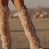 Blush pink faux feather leg warmers with shimmering sequin trim, styled over combat boots for a festival look.