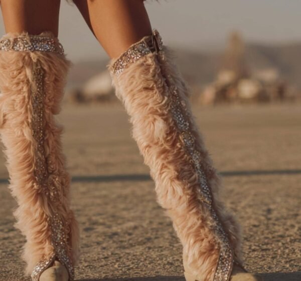 Blush pink faux feather leg warmers with shimmering sequin trim, styled over combat boots for a festival look.