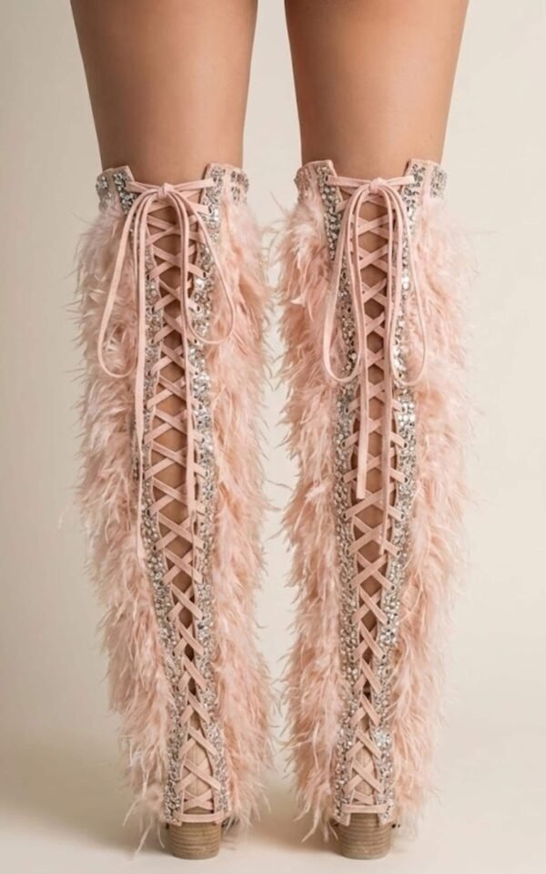 Blush pink faux feather leg warmers with shimmering sequin trim, styled over combat boots for a festival look.
