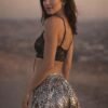 Model wearing the premium silver sequin hooded kaftan and matching shorts festival set at a rave.
