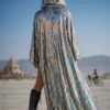 ZEVQ's custom holographic sequin duster, a shimmering festival kimono, worn at a vibrant event.