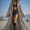 ZEVQ's custom holographic sequin duster, a shimmering festival kimono, worn at a vibrant event.