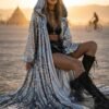 ZEVQ's custom holographic sequin duster, a shimmering festival kimono, worn at a vibrant event.