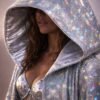 Model wearing a custom holographic silver festival duster kimono at a festival, showcasing its reflective, light-shifting properties.