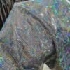 Model wearing a custom holographic silver festival duster kimono at a festival, showcasing its reflective, light-shifting properties.