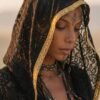 ZEVQ premium black lace hooded kaftan, a sheer festival kimono with gold trim, worn at a desert festival.