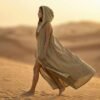 ZEVQ premium khaki linen hooded vest, a maxi festival duster with gold trim, modeled at a desert festival.