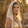White lace hooded maxi vest, a boho festival duster with gold trim, worn at a festival.